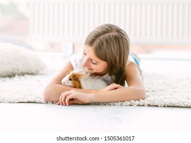 Girl Hugging Guinea Pig Softly Inside A House