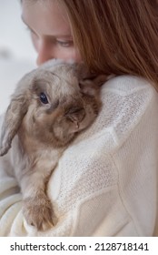 Girl Hugs A Cute White Rabbit At Home.a Girl With A Rabbit, Bunny Pet. Close Up