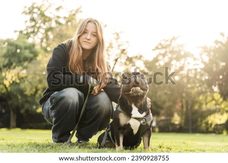 Girl hugs her French bulldog dog 