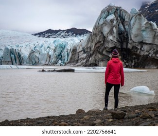 girl in icelandic knit cap standing in front of monumental glacier - Shutterstock ID 2202756641