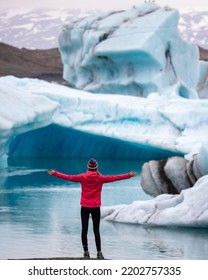 girl in icelandic knitted cap standing in front of huge, monumental icebergs in iceland, glacier lagoon - Shutterstock ID 2202757335