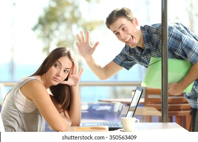 Girl ignoring and rejecting to a stalker man waving her in a coffee shop in a blind date - Shutterstock ID 350563409