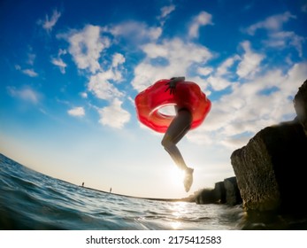 A Girl In An Inflatable Life Buoy Jumps Into The Sea Water. Summer Beach Activities. Wide Angle Go Pro. Blurred Image. No Focus