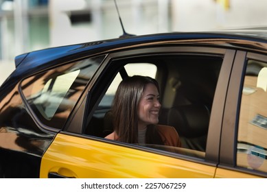Girl inside a cab in barcelona, cab window open, smiling woman talking to the driver, Caucasian with long straight hair.