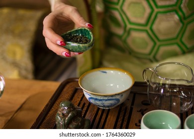 A girl in a Japanese kimono is holding a bowl with Chinese Lujing tea. Table with bowls, a wooden tray, a transparent cup. 
Good for restaurants, tea establishments, banners, posters, flyers.