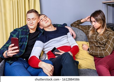 The Girl Is Jealous Of Her Boyfriend To His Friend. Bromance Is A Male Friendship With No Sexual Relationship. College Dorm With Students In The Common Room. Young Man Takes Selfie Using Smartphone.