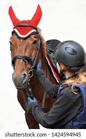 Girl In A Jockey Outfit With A Beautiful Brown Horse Isolated On White Background