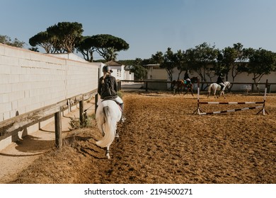 Girl Jogging A White Horse Around An Equestrian Arena