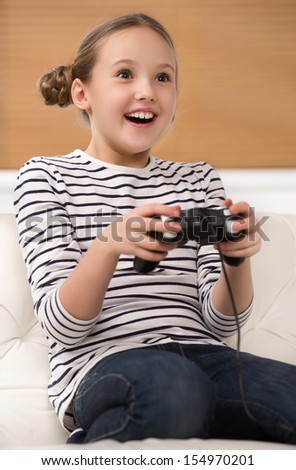 Similar – happy child playing video games with gamepad at home