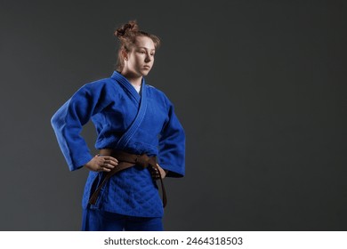 girl judoka in a white kimano with a black belt on a blue background, studio photo - Powered by Shutterstock