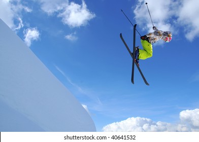 girl jumping with crossed skis over a steep cliff
