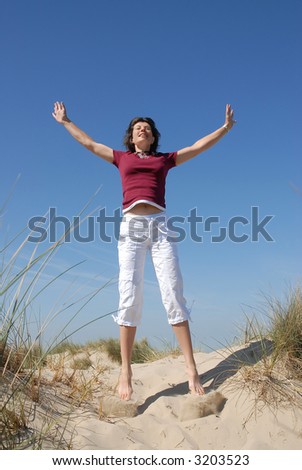 girl jumping for joy at the beach