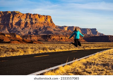 girl jumping for joy in the middle of nowhere in arizona, usa; girl lost in the american desert; empty road in usa during spring sunrise	 - Powered by Shutterstock