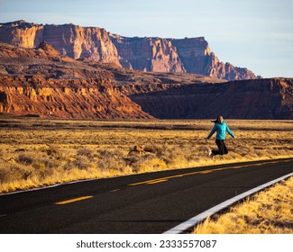 girl jumping for joy in the middle of nowhere in arizona, usa; girl lost in the american desert; empty road in usa during spring sunrise	 - Powered by Shutterstock