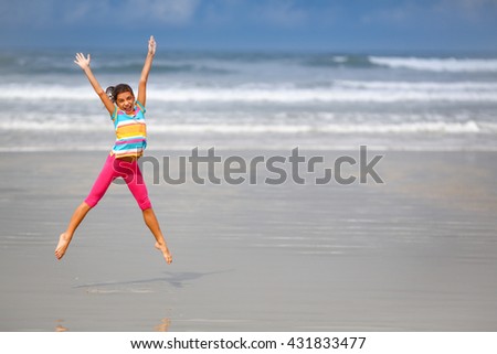 Girl jumping on the beach, Rio de Janeiro, Brazil