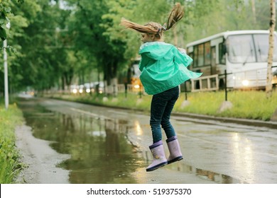 Girl Jumping In Puddles Spring Rain