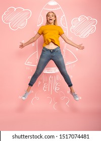 Girl jumps on pink background ready to fly like a rocket. Concept of freedom, energy and vitality - Shutterstock ID 1517074481