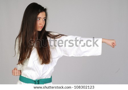 girl in Karate moves on grey background