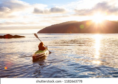 Girl Kayaking In The Pacific Ocean During A Cloudy Summer Sunset. Taken In San Josef Bay, Cape Scott, Northern Vancouver Island, BC, Canada.