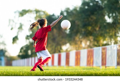 Mädchen tritt einen Fußball auf dem Fußballfeld