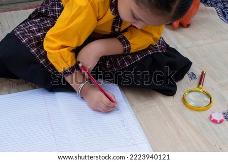 Girl Kid or toddler writing number in hindi or devnagri lipi or script notebook. Girl education, Learn Hindi and home schooling concept. Happy Mathematics Day and Hindi Diwas concept