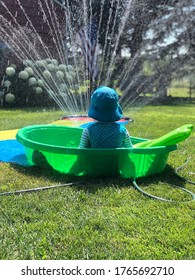 Girl In A Kiddie Pool Watching The Sprinkler