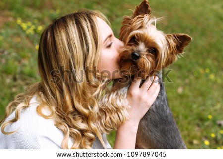 

The girl kisses the beloved Yorkshire terrier