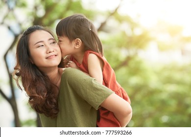 Girl kissing mother when she giving her piggyback ride - Powered by Shutterstock