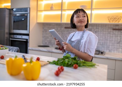 A Girl In The Kitchen Reading A Cookery Blog Online