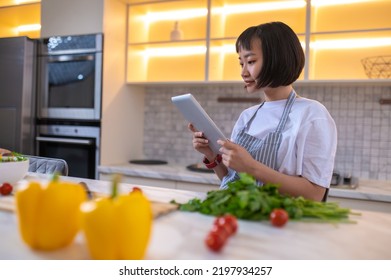 A Girl In The Kitchen Reading A Cookery Blog Online