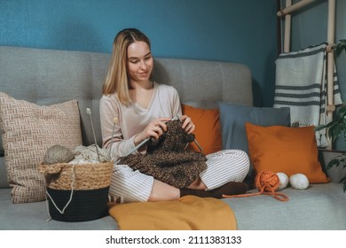 Girl knitting at home.Handmade zero waste,upcycling,New small business employment opportunity concept.Hobby knitting and needlework for mental health.Knitted background