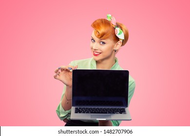 Mädchen mit Laptop. Nahaufnahme der roten Kopf schöne junge Frau, pinup Mädchen grün in grünem Knopfshirt mit PC-Bildschirm lächelnd Blick auf Ihre Kamera Retro-Vintage-Frisur auf rosafarbenem Hintergrund