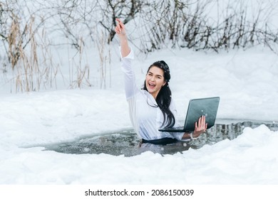 Girl with laptop in frozen lake ice hole. Woman hardening the body in cold water. Good immunity is protection against many diseases.