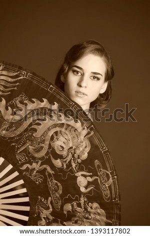 Girl with large Chinese fan. Asian, hieroglyph.