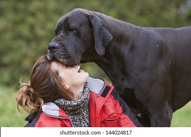 girl laughing while her dog kisses. tender moment,