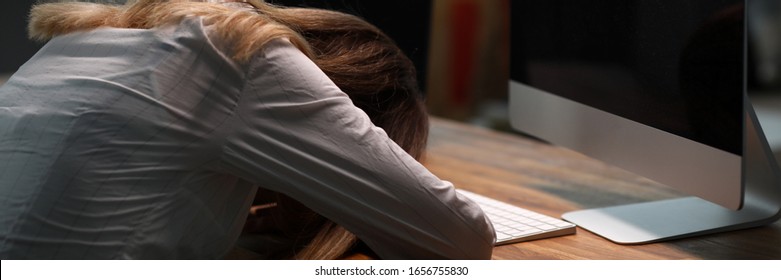 Girl Lay On Table In Office And Turned Off Monitor. Sedentary Lifestyle Carries Load On Spine, Impaired Circulation. Woman Used Limited Supply Mental Energy. Woman Sat Up At Work Until Evening.