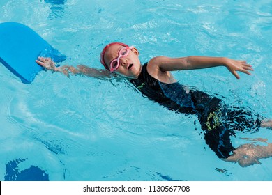 A Girl Learn How to Swim in Swimming Class, Kid Learning Activity Concept. - Powered by Shutterstock