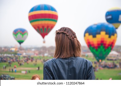 A Girl In A Leather Jacket And Short Braided Brown Hair Stares At Balloons, Hot Air Balloons