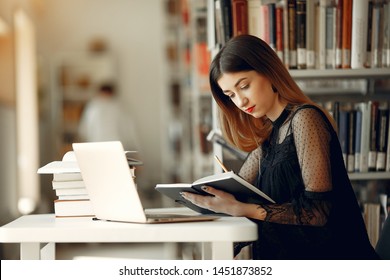 Girl in a library. Lady in a black dress. Student with a books.