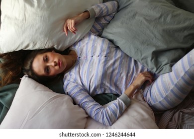 girl lies in bed with pillows