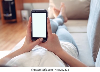 The girl lies on a sofa with a phone in his hand. Online shopping concept