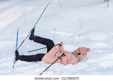 Girl Lies On White Snow After Ski Fall. Trying To Get Up 