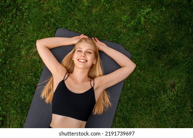 Girl Lies On A Yoga Mat, Sincere Smile, Rest After Training, Happy Woman, Karemat On The Background Of Grass, Outdoor Sports, Exercises, Top View, Studio, Yoga Classes