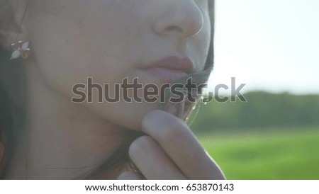 Girl lips. Girl is standing on the nature hair touch lips, strong lifestyle wind