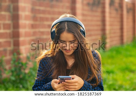Girl listening to music with headphones on the street, dancing, enjoying