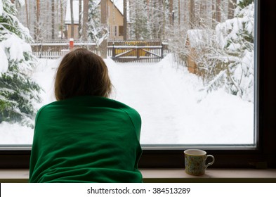 Girl Look Into The Window And See Winter Snow. Village Wooden House In The Forest.