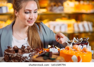 Girl Looking At The Bakery Window With Different Pieces Of Cakes