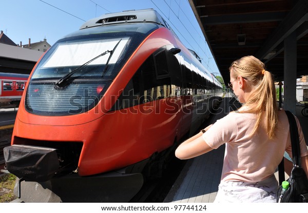 Girl looking at\
her watch at the train\
station