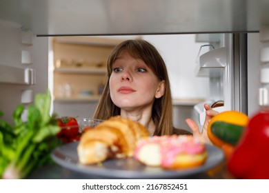 Girl Looking Inside Fridge Of Full Of Different Food