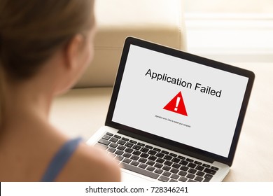 Girl Looking At Laptop With Application Failed Error On Screen. Software Failure, App Stopped Working, Computer Unit Broke, System Crashed Unexpectedly, Malware Concept. Close Up, Focus On Screen.